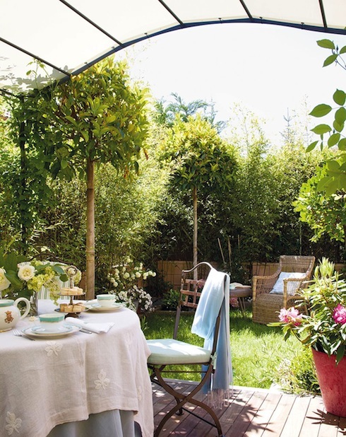 zona_de_estar_en_el_jardin_con_pergola_y_mesa_con_mantel_rosa_1015x1280